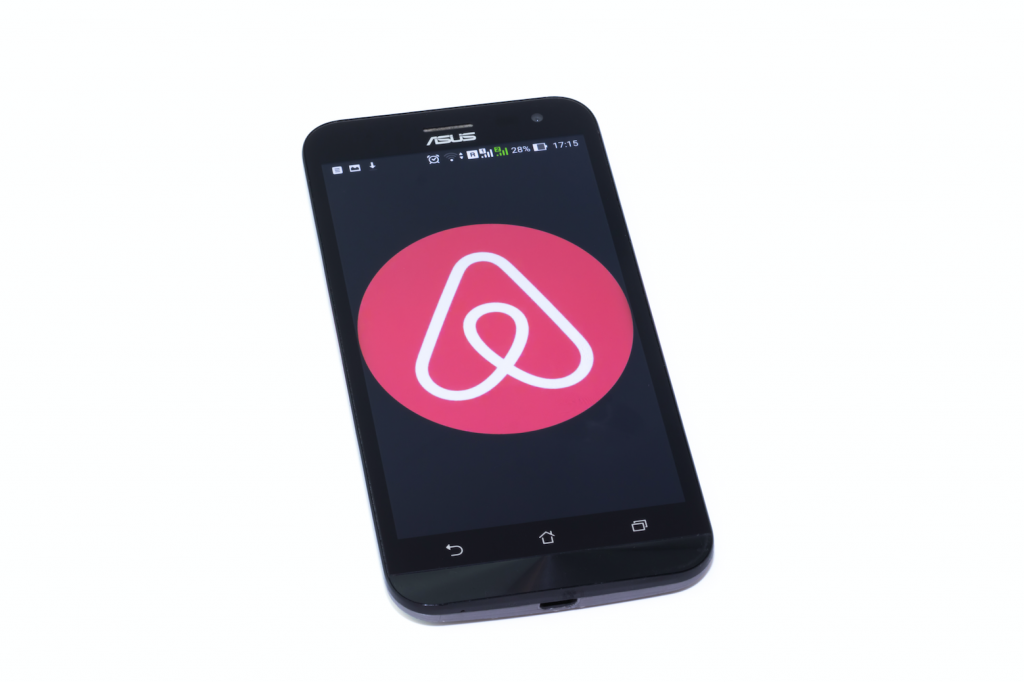 A phone displaying the Airbnb logo.